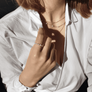 Na zdjęciu jest kobieta z pierścionkiem z perełek na dłoni.