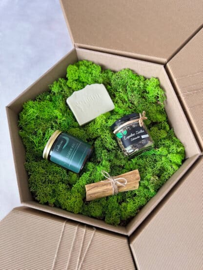 Na zdjęciu jest pudełko prezentowe "Święty spokój", w którym znajdują się: świeca sojowa, mydło naturalne, liściasta herbata i palo santo.
