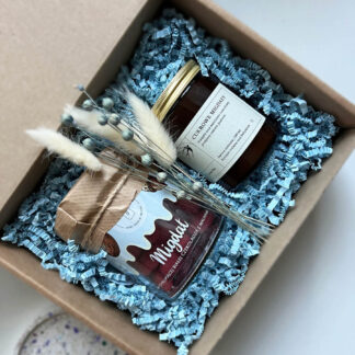 Na zdjęciu jest prezent "Niebieskie migdały" ze słoikiem migdałów w czekoladzie i świecą sojową