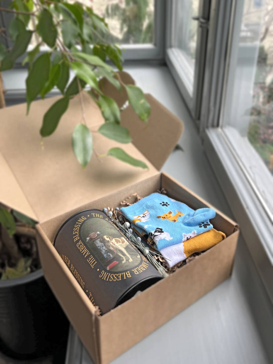 Na zdjęciu jest prezent dla psiarzy "Pieskie życie" z herbatą i kolorowymi skarpetkami