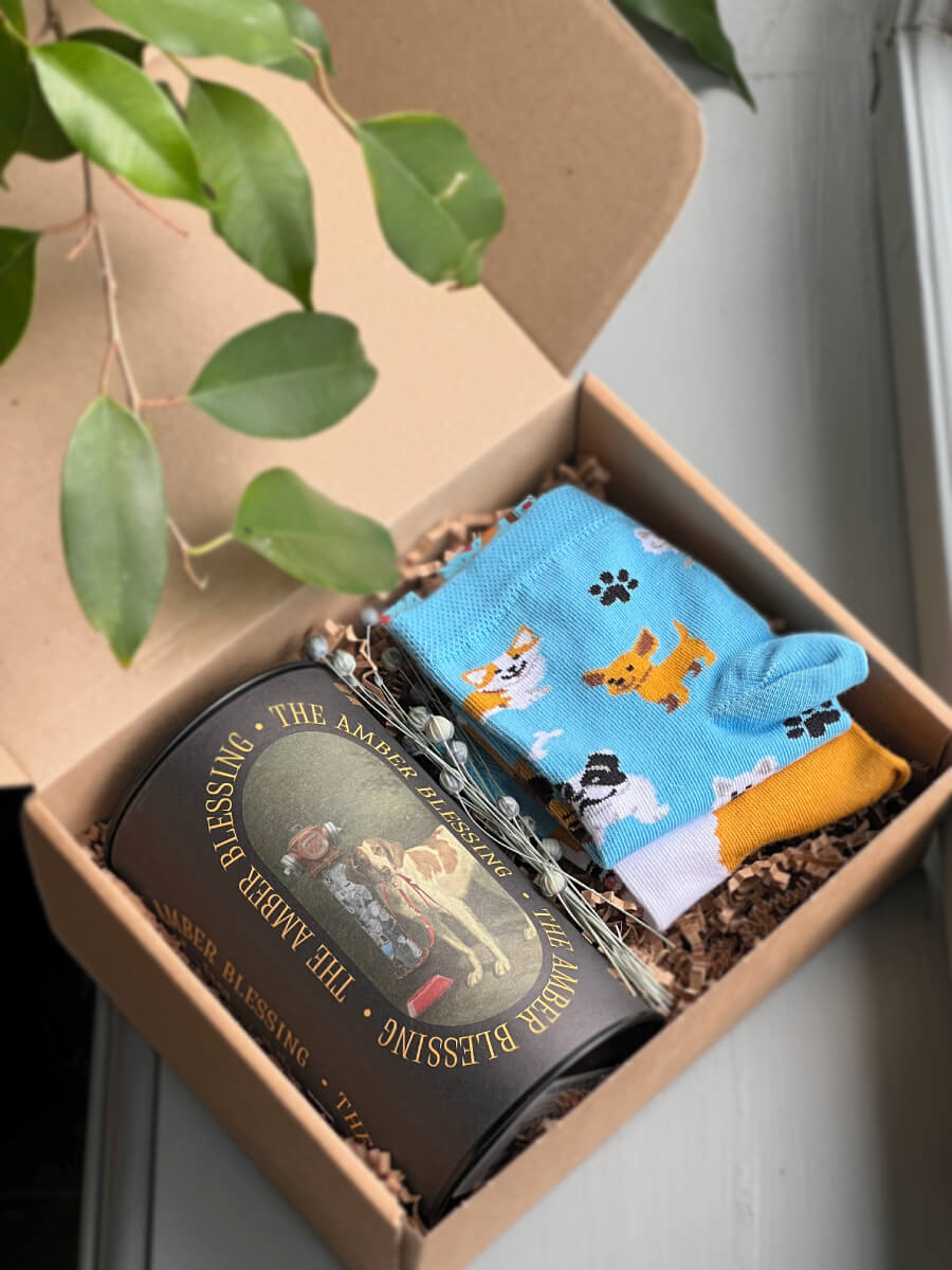 Na zdjęciu jest prezent dla psiarzy "Pieskie życie" z herbatą i kolorowymi skarpetkami